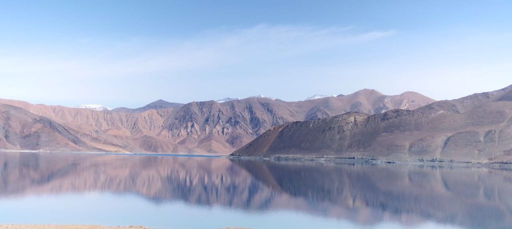 Mirror-like lake with pink mountains